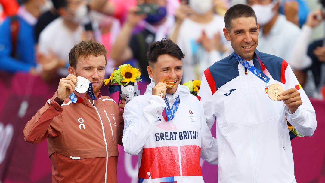 IZU, JAPÓN - 26 DE JULIO: (LR) El medallista de plata Mathias Flueckiger del Team Switzerland, el medallista de oro Thomas Pidcock del Team Great Britain muerde su medalla y el medallista de bronce David Valero Serrano del Team Spain, posan en el podio durante la ceremonia de entrega de medallas durante la Carrera de campo traviesa masculina en el tercer día de los Juegos Olímpicos de Tokio 2020 en Izu Mountain Bike Course el 26 de julio de 2021 en Izu, Shizuoka, Japón.  (Foto de Tim de Waele / Getty Images)