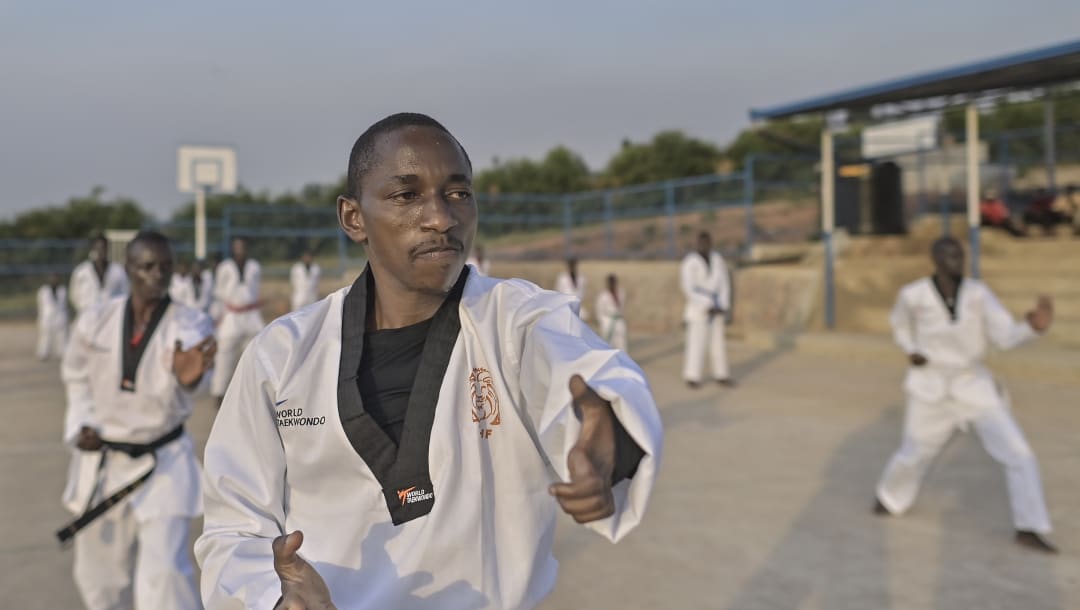 Parafait Hakizimana imparte una lección para estudiantes junior de taekwondo en la Escuela Paysannat L