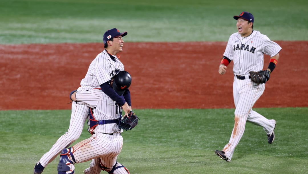 YOKOHAMA, JAPÓN - 07 DE AGOSTO: (LAR) El lanzador Ryoji Kuribayashi # 20, el receptor Takuya Kai # 10 y el jugador de cuadro Munetaka Murakami # 55 del equipo de Japón celebran ganar el oro después de su victoria por 2-0 en el juego por la medalla de oro entre el Team United Estados Unidos y el equipo de Japón en el día quince de los Juegos Olímpicos de Tokio 2020 en el estadio de béisbol de Yokohama el 7 de agosto de 2021 en Yokohama, Kanagawa, Japón.  (Foto de Koji Watanabe / Getty Images)