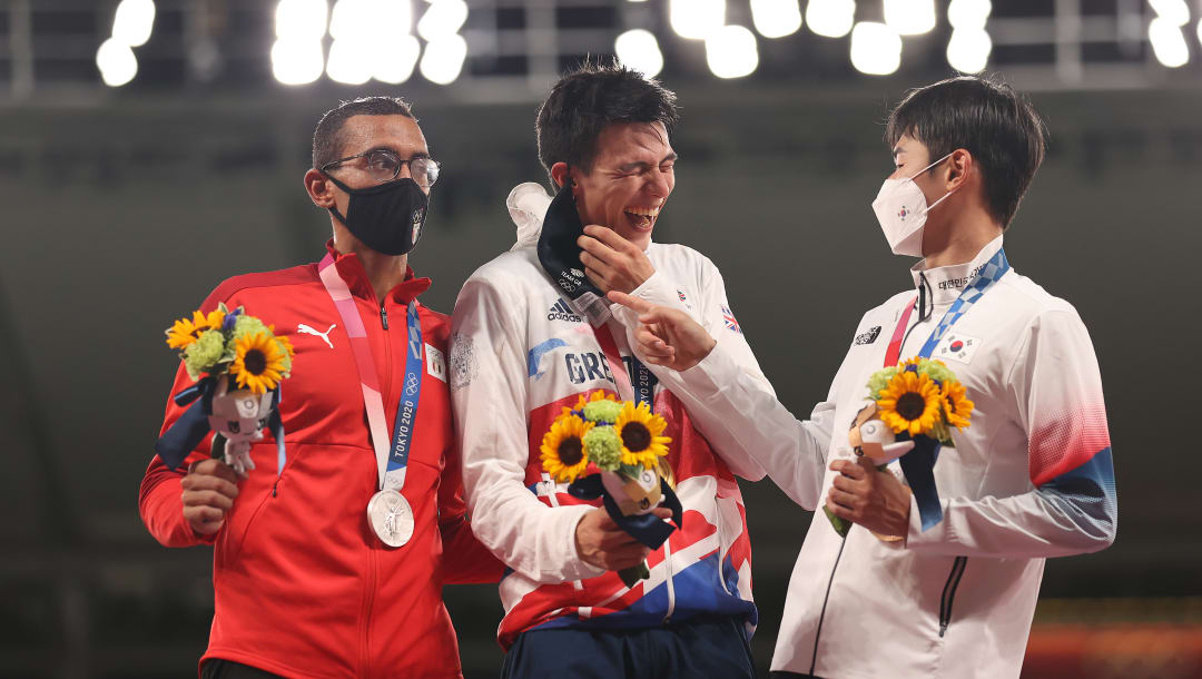 CHOFU, JAPÓN - 7 DE AGOSTO: El medallista de bronce Woongtae Jun del equipo de la República de Corea (R) ayuda al medallista de oro Joseph Choong del equipo de Gran Bretaña después de que su máscara se deslice accidentalmente durante la ceremonia de entrega de medallas del Pentatlón Moderno Masculino en el día quince de los Juegos Olímpicos de Tokio 2020 Juegos en el estadio de Tokio el 7 de agosto de 2021 en Chofu, Japón.  (Foto de Dan Mullan / Getty Images)